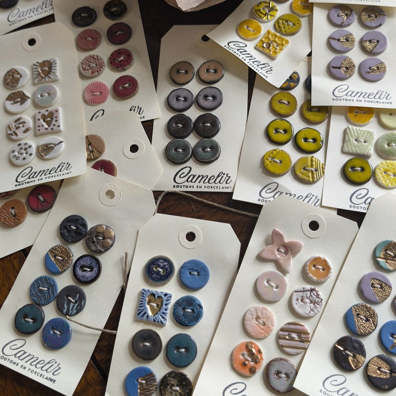 Collection of buttons on display cards with 'Camelir' branding.