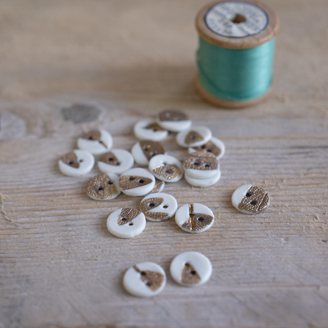 Thread spool and buttons on a wooden surface