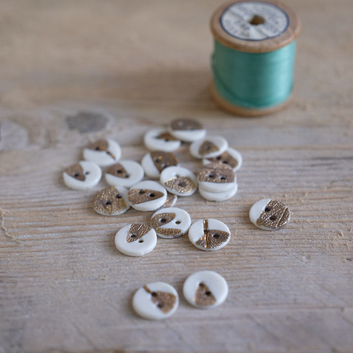 Thread spool and buttons on a wooden surface