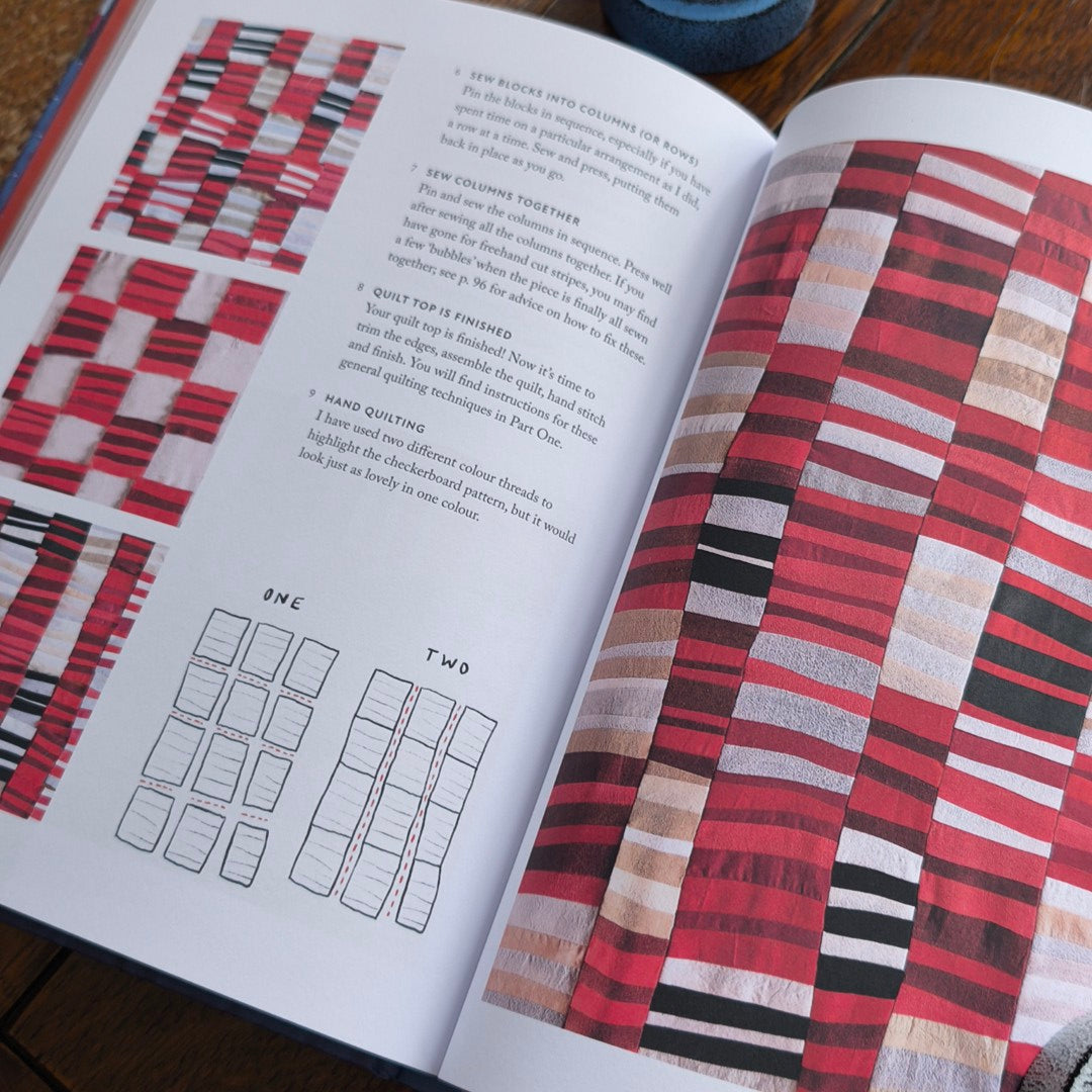 Open book with fabric swatches and text on a wooden surface