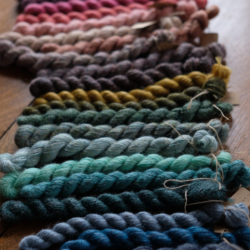 Row of colorful yarn skeins on a wooden surface