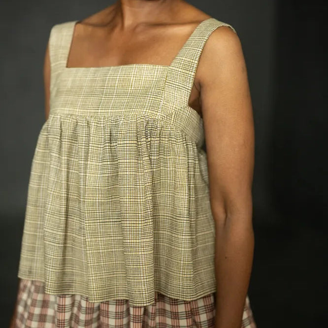 Woman wearing a plaid dress against a black background