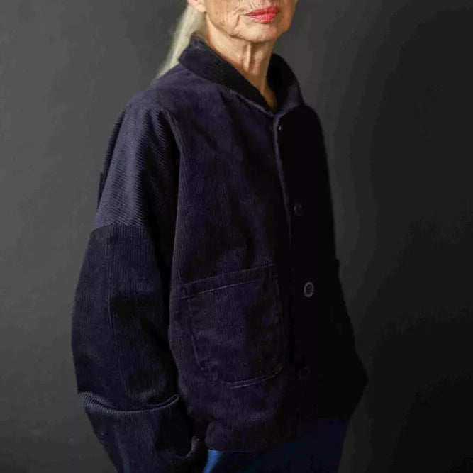 Woman wearing a dark jacket against a black background