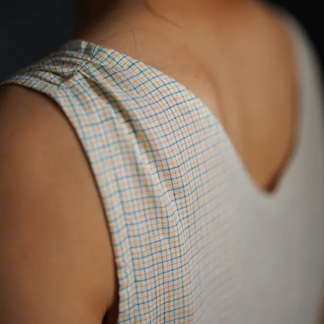 Close-up of a sleeveless garment with a checkered pattern on a blurred background