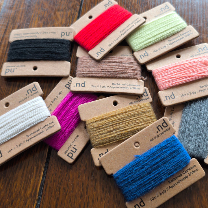 Assorted spools of cashmere thread on cards